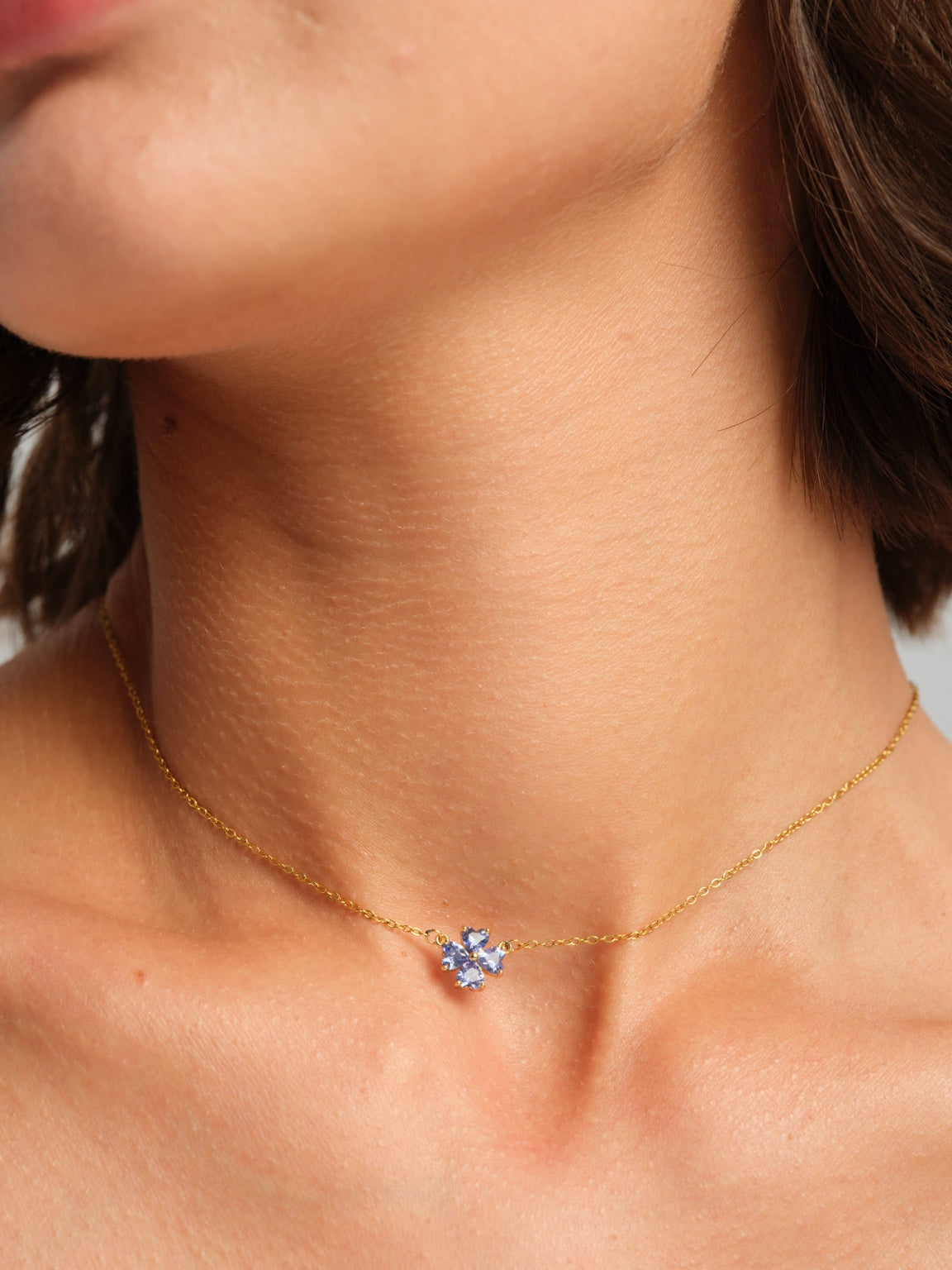 Blue floral necklace worn on a model, angled close-up