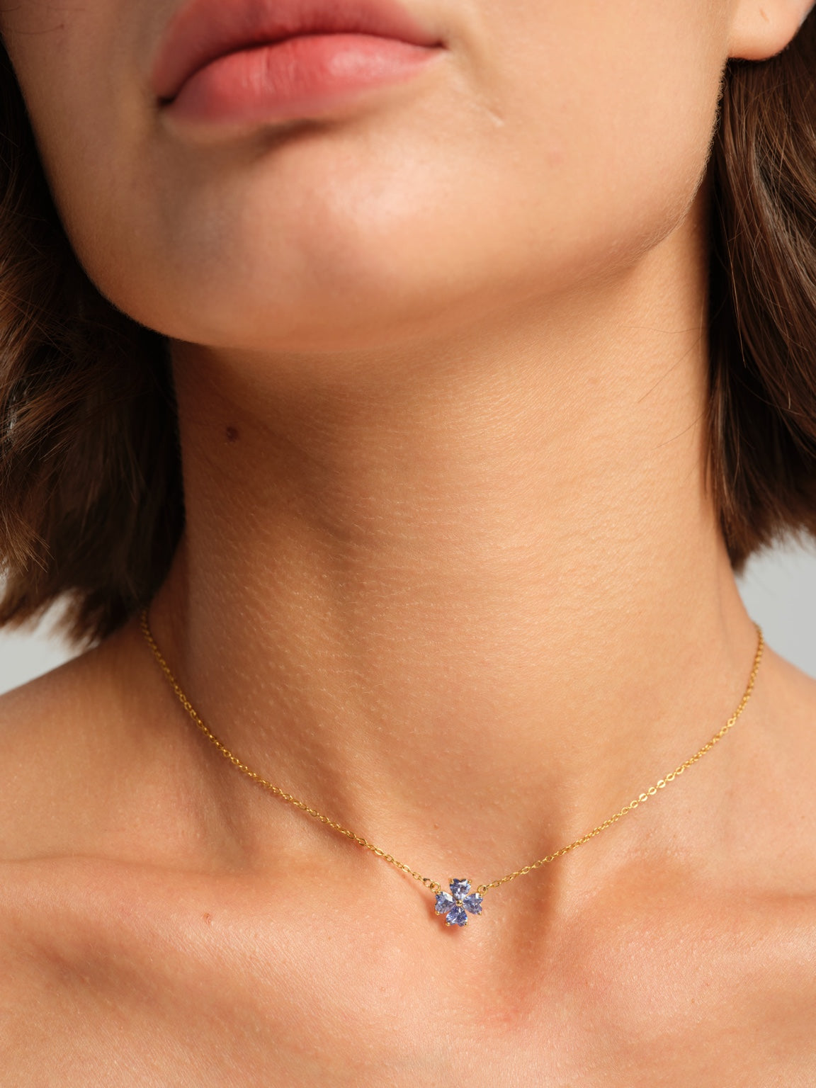 Blue floral necklace worn on a model, close-up front view
